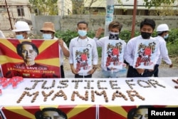 People hold a banner showing the portrait of Aung San Suu Kyi, in Mandalay, Myanmar February 19, 2021 in this picture obtained by REUTERS.