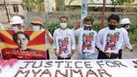 People hold a banner showing the portrait of Aung San Suu Kyi, in Mandalay, Myanmar February 19, 2021 in this picture obtained by REUTERS.