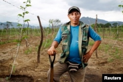 Farmer Ricardo Julca poses while irrigating his crops after a rare rain in the outskirts of Olmos, March 14, 2013.