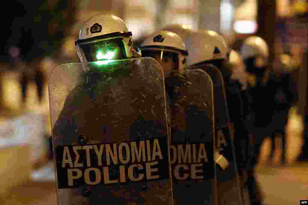 A Greek riot police officer is attacked with a laser pointer during clashes in front of parliament, in central Athens, on February 19, 2012. (AP)