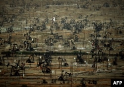 FILE - A general view shows oil pumping jacks and drilling pads at the Kern River Oil Field, where the principle operator is the Chevron Corporation, in Bakersfield, California, July 28, 2015.