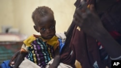FILE - Nyagoah Taka Gatluak, a severely malnourished one-year-old child, sits on her mother's lap in the Doctors Without Borders clinic in Leer town, South Sudan.
