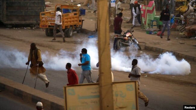 Tear gas disperses Sudanese demonstrators during anti-government protests in the outskirts of Khartoum, Sudan, Jan. 15, 2019.