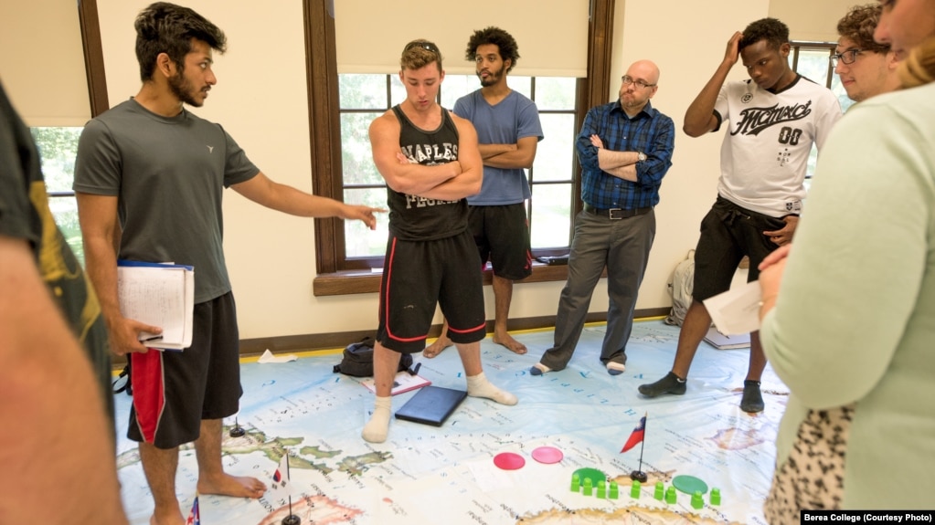 Standing on a map of Asia, Berea College students in a foreign policy class work policy on a crisis exercise. Berea, in Kentucky, offers free tuition to all its students.
