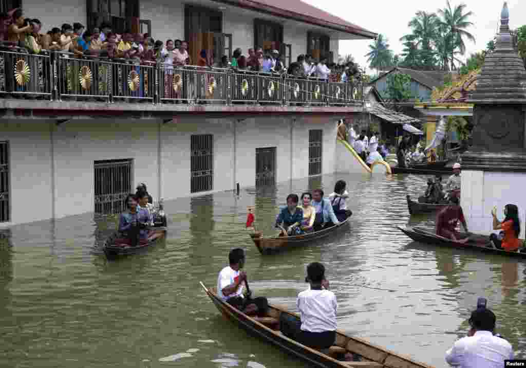 Myanmar opposition leader Aung San Suu Kyi (center) leaves a monastery by boat after visiting flood victims sheltered in Bago, 80 kilometers northeast of Yangon, Myanmar, Aug. 3, 2015.