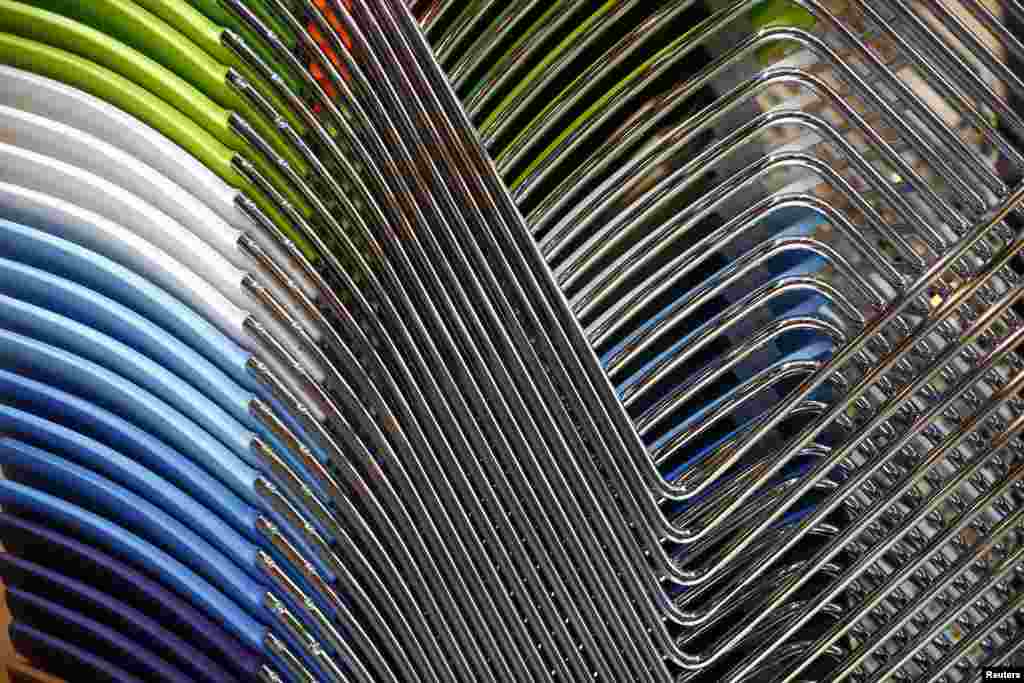 Office chairs are stacked together on a stand at the 100% Design Exhibition at Earl's Court in London.