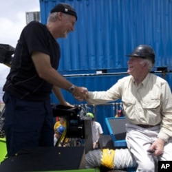 James Cameron is congratulated by U.S. Navy Capt. (Ret) Don Walsh, right, after completing the first ever solo dive down to the lowest part of the Mariana Trench, part of the Deepsea Challenge, a joint effort with National Geographic. Walsh took the same