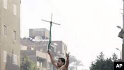 Angry Egyptian Christians smash a police vehicle as they raise a cross during a riot, which left one one person dead, after authorities halted construction on a church saying the local Christian community had violated a building permit, in Cairo, Egypt, W