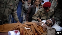 Военные медики эвакуируют пострадавшего при взрыве у центра агентства ООН. Пакистан. 25 декабря 2010 года