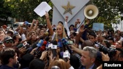 Lilian Tintori, wife of jailed Venezuelan opposition leader Leopoldo Lopez, holds up a letter from her husband as she speaks during a news conference in Caracas, Sept. 11, 2015.