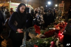 A woman lays flowers at the well-known military choir's building in Moscow, Dec. 25, 2016.