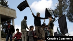 Protesters carry Jabhat al-Nusra flags and shout slogans during an anti-government protest after Friday prayers in the town of Marat Numan in Idlib province, Syria, March 11, 2016.