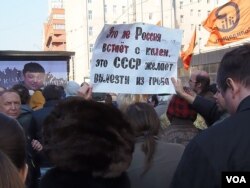 2014年4月莫斯科的一场反对官方媒体宣传入侵乌克兰，煽动战争的抗议集会上，一名示威者手举标语认为，今天的俄罗斯并没有挺直腰杆站了起来，而是苏联想从棺材中爬出。（美国之音白桦拍摄）