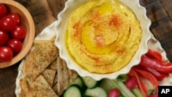 FILE - This Jan. 20, 2017, file photo shows roasted carrot hummus with crudite and pita chips at the Institute of Culinary Education in New York.