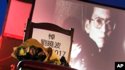A bouquet of flowers is placed on a chair that reads ''Mourning Liu Xiaobo'' in front of his image during a ceremony to mourn late Nobel Peace Prize laureate Liu, China's most famous political prisoner, at Democracy Square in Taipei, Taiwan, July 14, 2017.