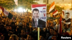 Members of the Muslim Brotherhood and supporters of deposed Egyptian President Mohamed Morsi shout slogans and hold up posters during a rally marching back towards Rabaa al-Adawiya Square where they are camping, in Cairo, August 2, 2013.