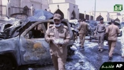 FILE - In this image from Saudi TV video, investigators collect evidence in the aftermath of a suicide bombing outside the Imam Hussein mosque in Dammam, Saudi Arabia, May 29, 2015.