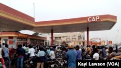 Des motocyclistes devant un distributeur, à Lomé, au Togo, le 2 janvier 2018. (VOA/Kayi Lawson)