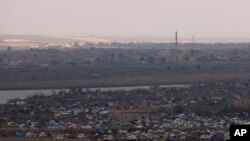The Islamic State group's last pocket of territory in Baghouz, Syria, as seen from a distance on Sunday, March 17, 2019.