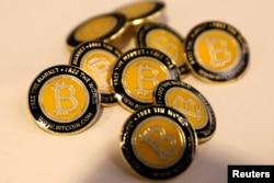FILE - Bitcoin.com buttons are seen displayed on the floor of the Consensus 2018 blockchain technology conference in New York City, New York, May 16, 2018.