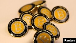 FILE - Bitcoin.com buttons are seen displayed on the floor of the Consensus 2018 blockchain technology conference in New York City, New York, May 16, 2018.