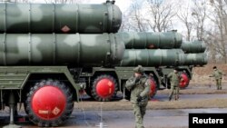 FILE - Russian servicemen stand next to a new S-400 "Triumph" surface-to-air missile system after its deployment at a military base outside the town of Gvardeysk near Kaliningrad, Russia, March 11, 2019. 