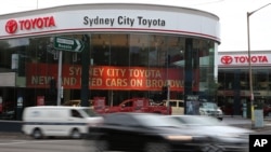 FILE - Vehicles speed past a Toyota dealership in Sydney.