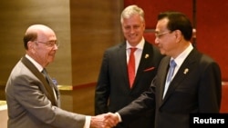 美國商務部長羅斯（左）與中國總理李克強在東盟峰會上握手，美國國家安全顧問奧布萊恩站立在兩人身旁。（2019年11月4日）