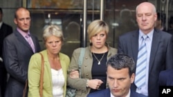 File photo shows the family of murdered teenager Milly Dowler (L-R), mother Sally Dowler, sister Gemma and father Bob standing behind their lawyer Mark Lewis after meeting Rupert Murdoch at a hotel in central London, July 15, 2011
