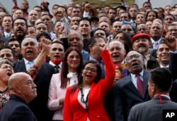 The President of Venezuela's Constituent Assembly Delcy Rodriguez, front and center, leads the newly sworn-in Constituent Assembly as they pose for an official photo in front of Venezuela's National Assembly in Caracas, Venezuela, Aug. 4, 2017.