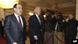 Iraq's Prime Minister Nouri al-Maliki (L) walks with U.S. Vice President Joe Biden, center, after his arrival for a meeting in Baghdad, Iraq, 13 Jan 2011