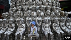 A boy sits on a chair amongst sculptures on display at a shopping centre on International Children's Day in Beijing on June 1, 2021, a day after China announced it would allow couples to have three children. 