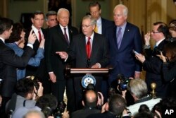 Senate Majority Leader Mitch McConnell of Ky., center, calls on a reporter during a news conference with Republican leadership, Tuesday, Nov. 28, 2017, on Capitol Hill in Washington, after President Donald Trump visited the Capitol.