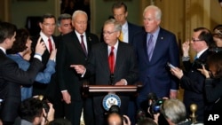 Senate Majority Leader Mitch McConnell of Kentucky, center, calls on a reporter during a news conference with Republican leadership on Capitol Hill in Washington, after President Donald Trump visited the Capitol, Nov. 28, 2017.