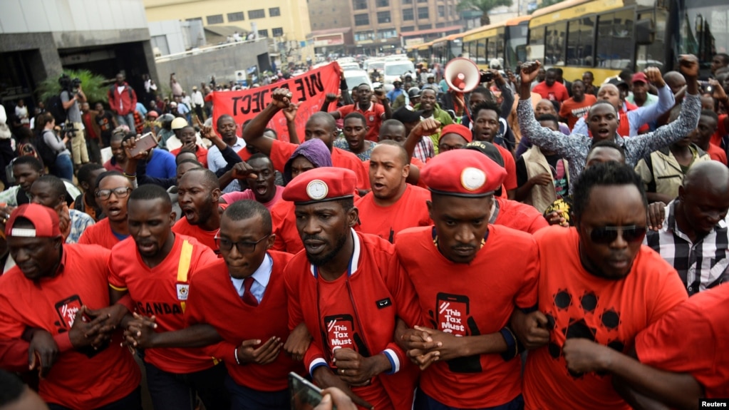 Mwanamuziki wa Ugandan ambaye hivi sasa ni mwanasiasa Robert Kyagulanyi (C) akiwaongoza maandamano ya wanaharakati kupinga kodi mpya ikiwemo kodi kwa watumiaji wa mitandao ya kijamii mjini Kampala, Uganda, Julai 11, 2018.