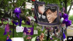 FILE - Items left by fans at a memorial for Prince hang from a fence outside the musician's Paisley Park estate in Chanhassen, Minnesota, May 11, 2016. 