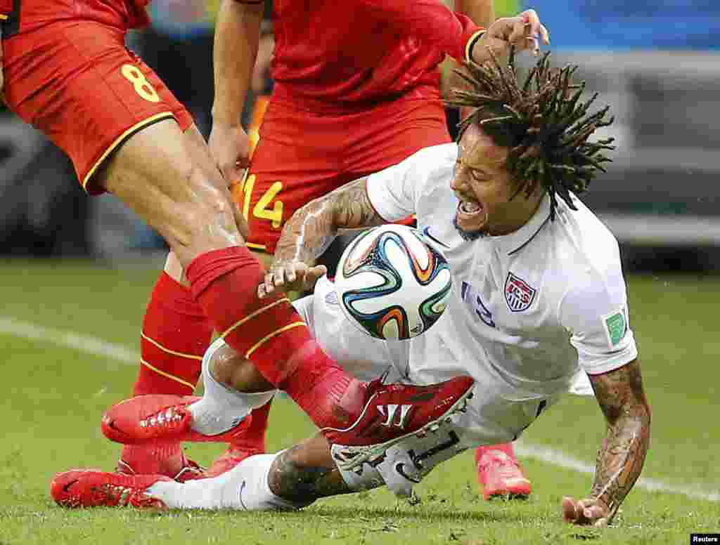 O jogador belga&nbsp;Marouane Fellaini chuta a bola enquanto o americano Jermaine Jones tenta bloqueá-la, durante o jogo na Arena Fonte Nova em Salvador, Julho 1, 2014.