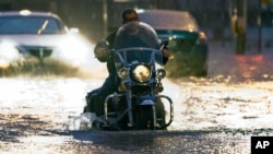 A man on a motorcycle drives through flood water on Western Ave. at NW 5th Street in Oklahoma City on Friday, May 31, 2013. 