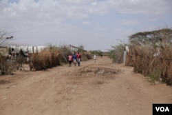 FILE- Residents are seen walking down a dirt road at Kakuma refugee camp, Kakuma, Kenya, on Feb. 6, 2017. (J. Craig/VOA)