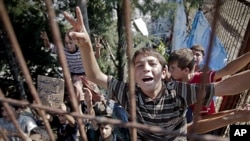 Syrian refugee children shout during a spontaneous protest they initiate against Syrian President Bashar al-Assad, in a camp in Yayladagi, Turkey, near the Syrian border, June 15, 2011
