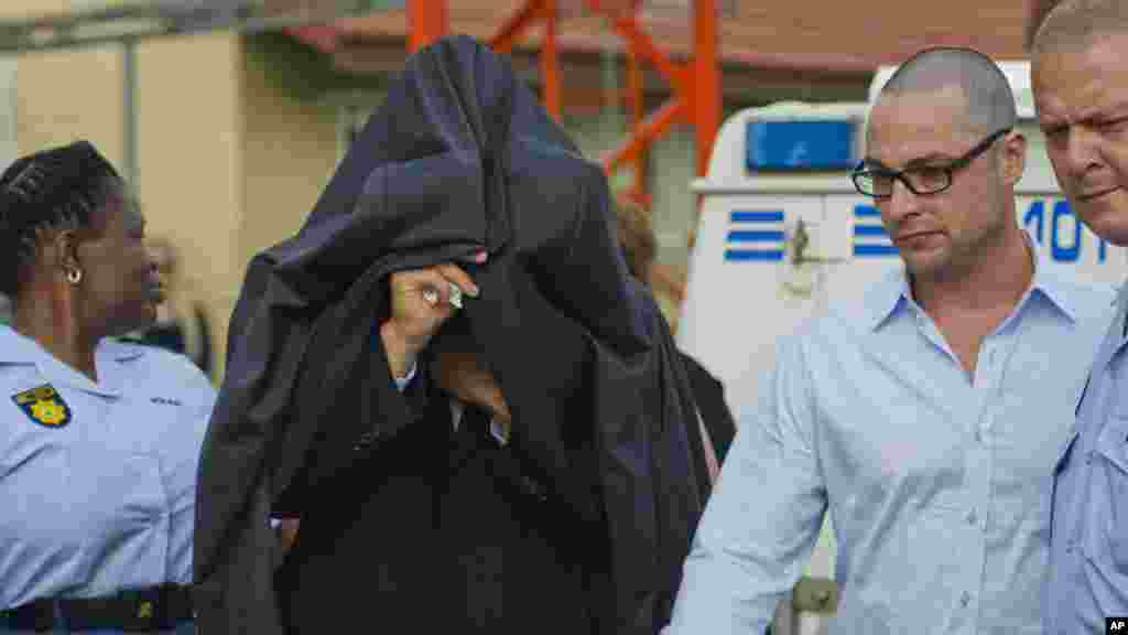 2012年2月15日，奥斯卡&middot;皮斯托利斯（中）被带离比勒陀利亚以东的博斯赫科普警察局，前往法庭。