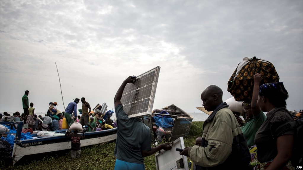 Des personnes embarquent dans des pirogues sur le lac Albert pour fuir les violences en Itrui vers l'Ouganda à Tchomia, le 5 mars 2018.