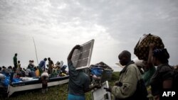 Des personnes embarquent dans des pirogues sur le lac Albert pour fuir les violences en Itrui vers l'Ouganda à Tchomia, le 5 mars 2018.