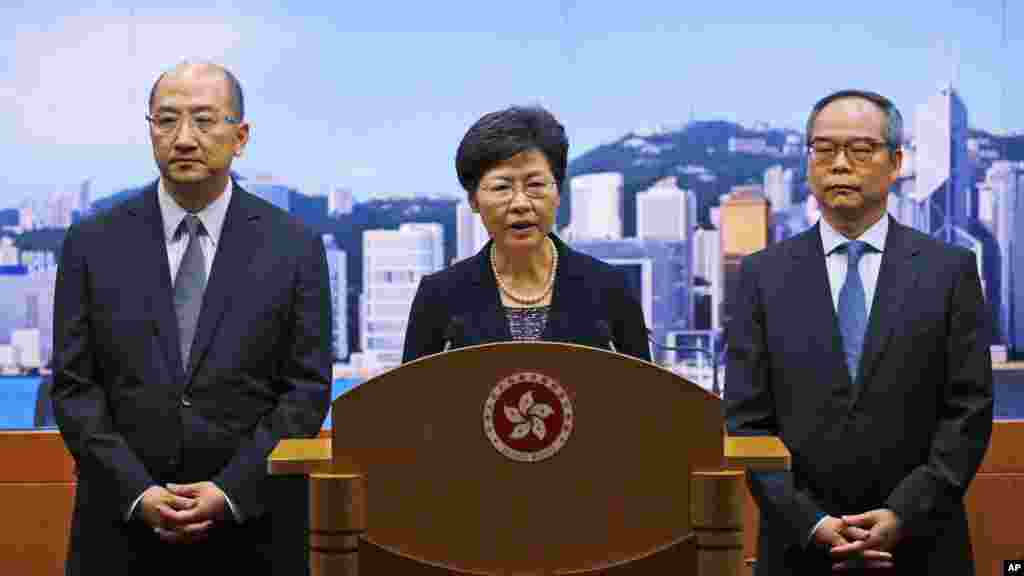 From left, Hong Kong Secretary for Constitutional and Mainland Affairs Raymond Tam Chi-yuen, Chief Secretary Carrie Lam and Constitutional Affairs Undersecretary Lau Kong-wah hold a news conference in Hong Kong, Oct. 9, 2014. 