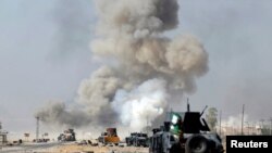 FILE - An improvised explosive device planted by Islamic State fighters explodes in front of Iraqi special forces vehicles in Bartella, east of Mosul, Iraq, Oct. 20, 2016.