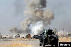 FILE - An improvised explosive device planted by Islamic State fighters explodes in front of Iraqi special forces vehicles in Bartella, east of Mosul, Iraq, Oct. 20, 2016.