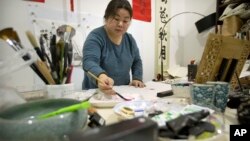 In this Feb. 27, 2017 photo, Ye Haiyan paints a watercolor painting in her studio on the outskirts of Beijing.