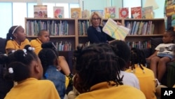FILE - Education Secretary Betsy DeVos reads to students at Eagle Academy Public Charter School in Washington, Friday, June 2, 2017. DeVos is a long time proponent of charter schools and school choice (AP Photo/Maria Danilova)