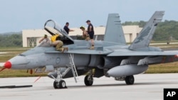 FILE - An Australian fighter jet is readied for a training mission at Andersen Air Force Base on the U.S. island of Guam, Feb. 7, 2013. Australia announced Friday that it would recall its fighter jets from Iraq and Syria.