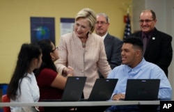 FILE - Democratic presidential candidate Hillary Clinton talks with students as she tours classrooms at John Marshall High School in Cleveland, Aug. 17, 2016.